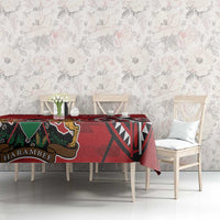 Red tablecloth with HARAMBEE label and coat-of-arms figure, over dining table