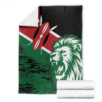 Green lion head blanket with red flag symbol and black top, neatly folded