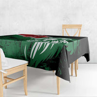 Green and black rectangular tablecloth with lion head and flag-style design on dining table.