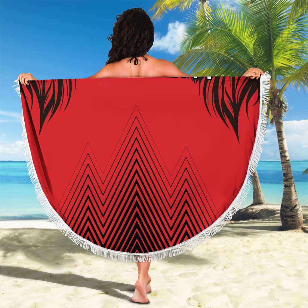 Red round beach blanket with fringed edge, bold lion print, '00' and chevron pattern.