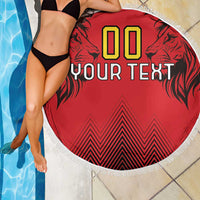 Red round beach blanket with fringed edge, lion artwork, '00' 'YOUR TEXT' and chevrons.