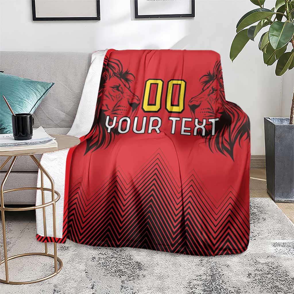 Red rugby blanket draped over chair with lion head artwork, “00 YOUR TEXT,” zigzag pattern