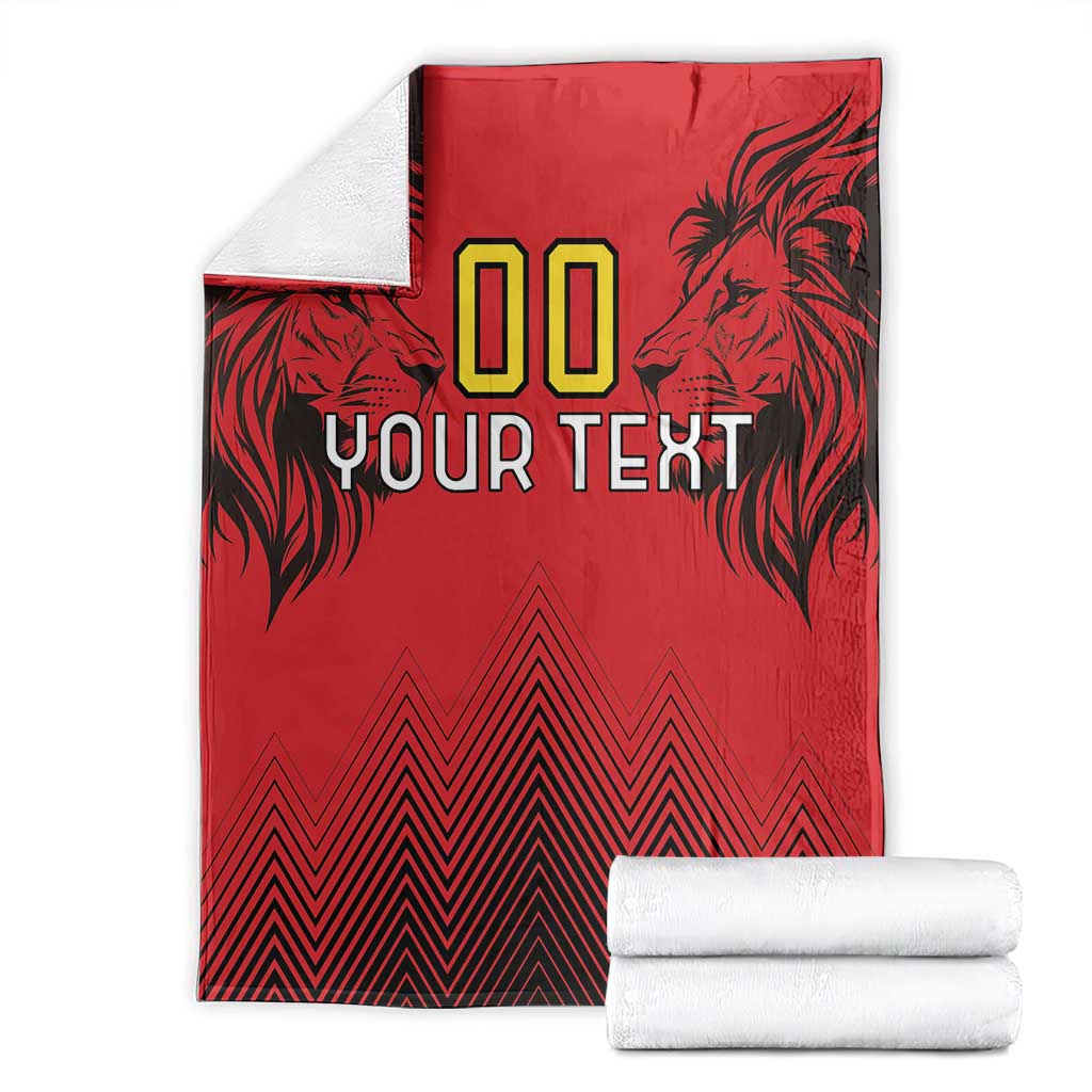 Folded red rugby blanket with lion head graphics, “00 YOUR TEXT,” zigzag pattern, with rolls