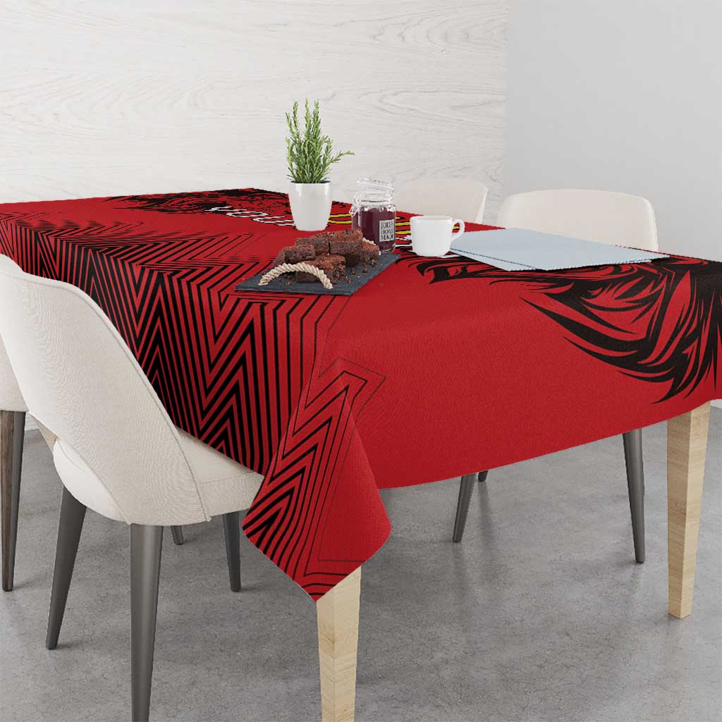 Red and black rugby tablecloth with lion head and geometric stripes pattern on a square table.