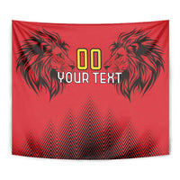 Red tapestry close-up with two black lion heads, zigzag base, and 'YOUR TEXT' design