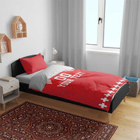Red duvet bedding with two red pillows; white “DO YOUR TEXT” and cross-pattern lower edge.