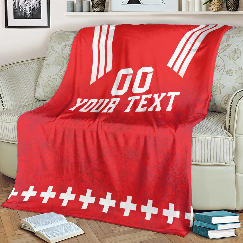 Red rugby blanket on sofa with white 'YOUR TEXT' and striped top corners