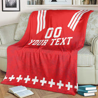 Red rugby blanket on sofa with white 'YOUR TEXT' and striped top corners