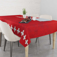Red rugby tablecloth with white cross pattern draped over a dining table