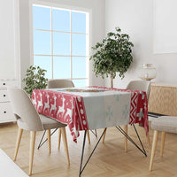 Red Christmas tablecloth with boat nativity scene and geometric panel on a dining table