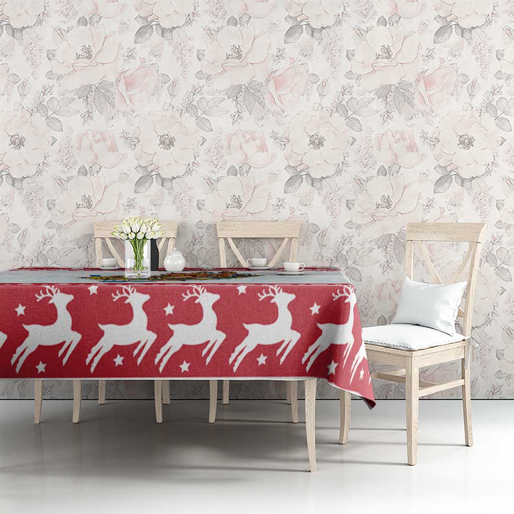 Red Christmas tablecloth with white reindeer and stars on a dining table with chairs