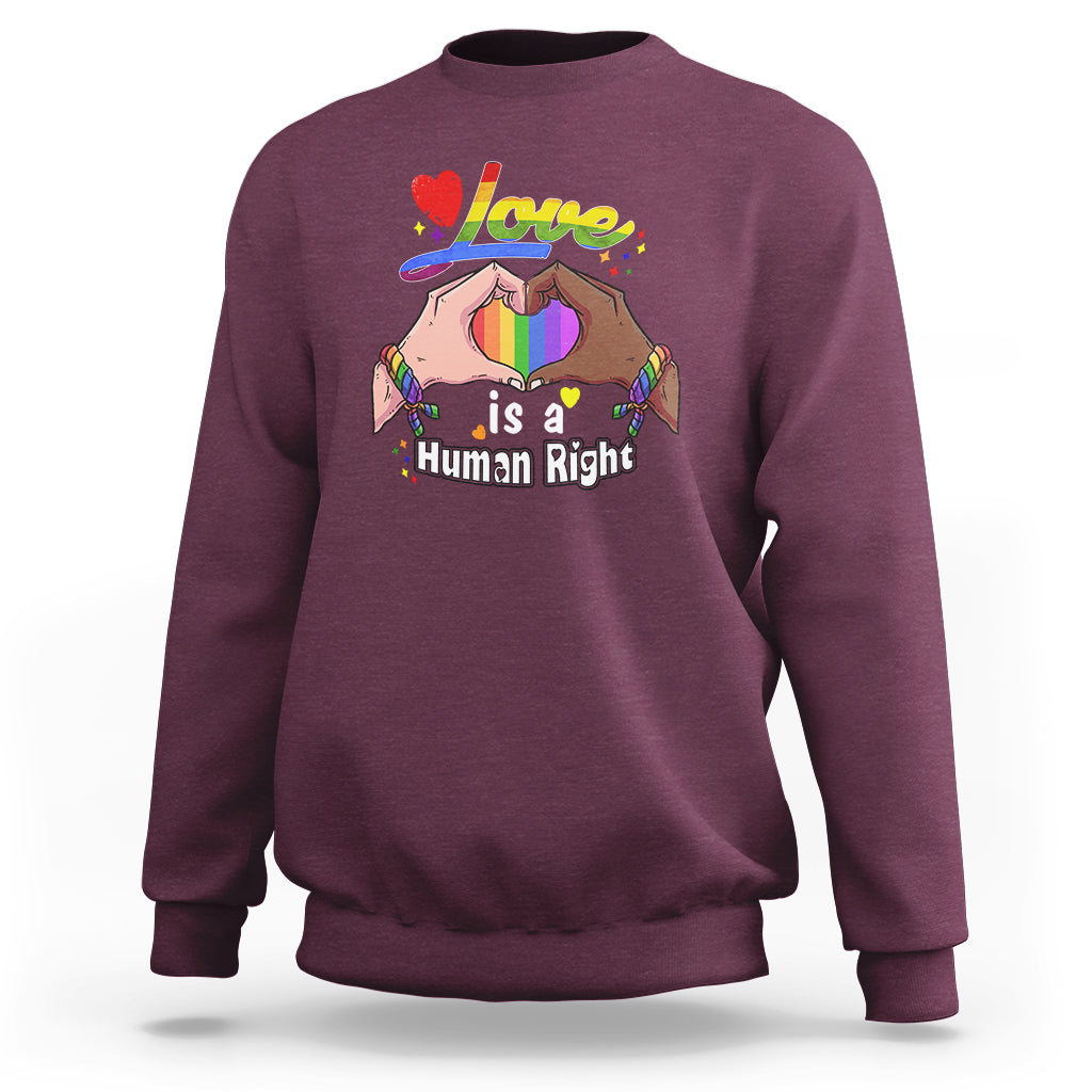 Maroon crewneck sweatshirt, long sleeves, “Love is a Human Right” heart graphic