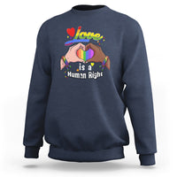 Blue crewneck sweatshirt, long sleeves, “Love is a Human Right” heart graphic