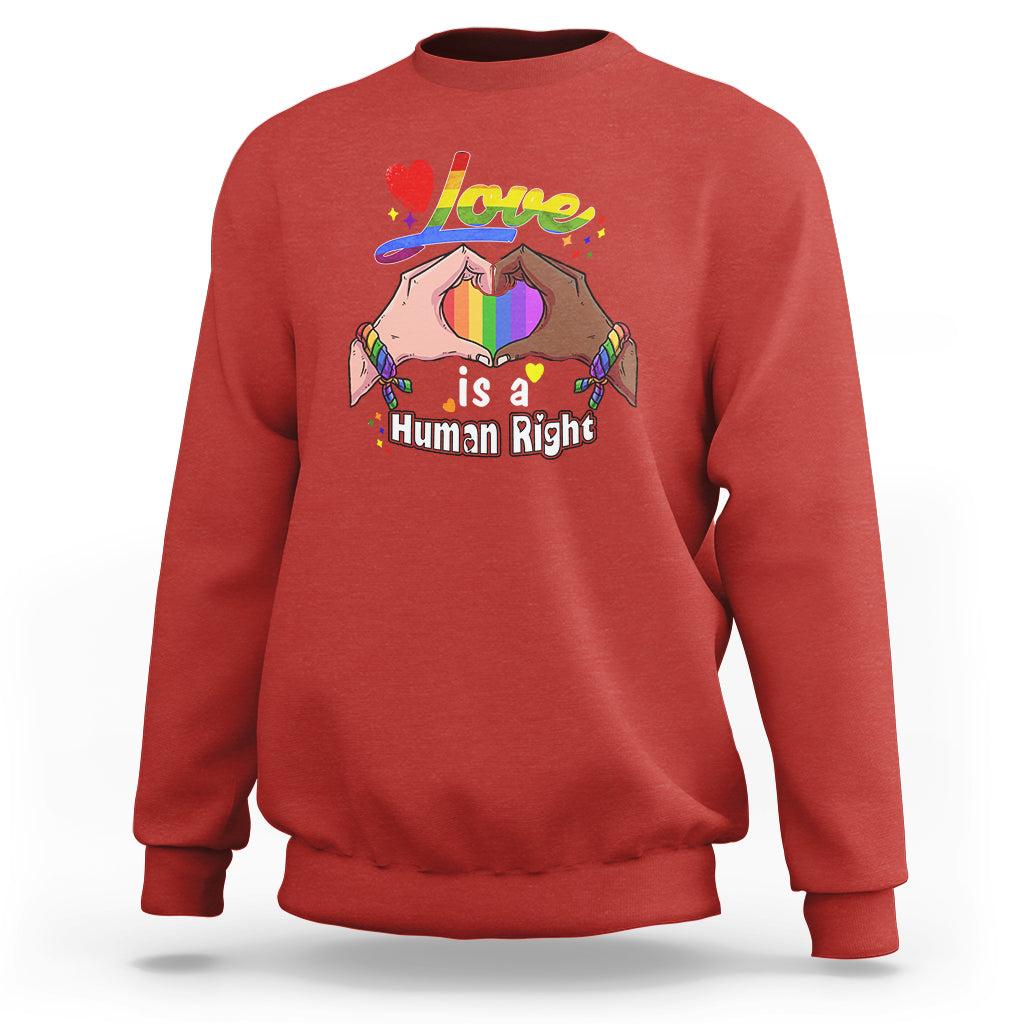 Red crewneck sweatshirt, long sleeves, “Love is a Human Right” heart graphic
