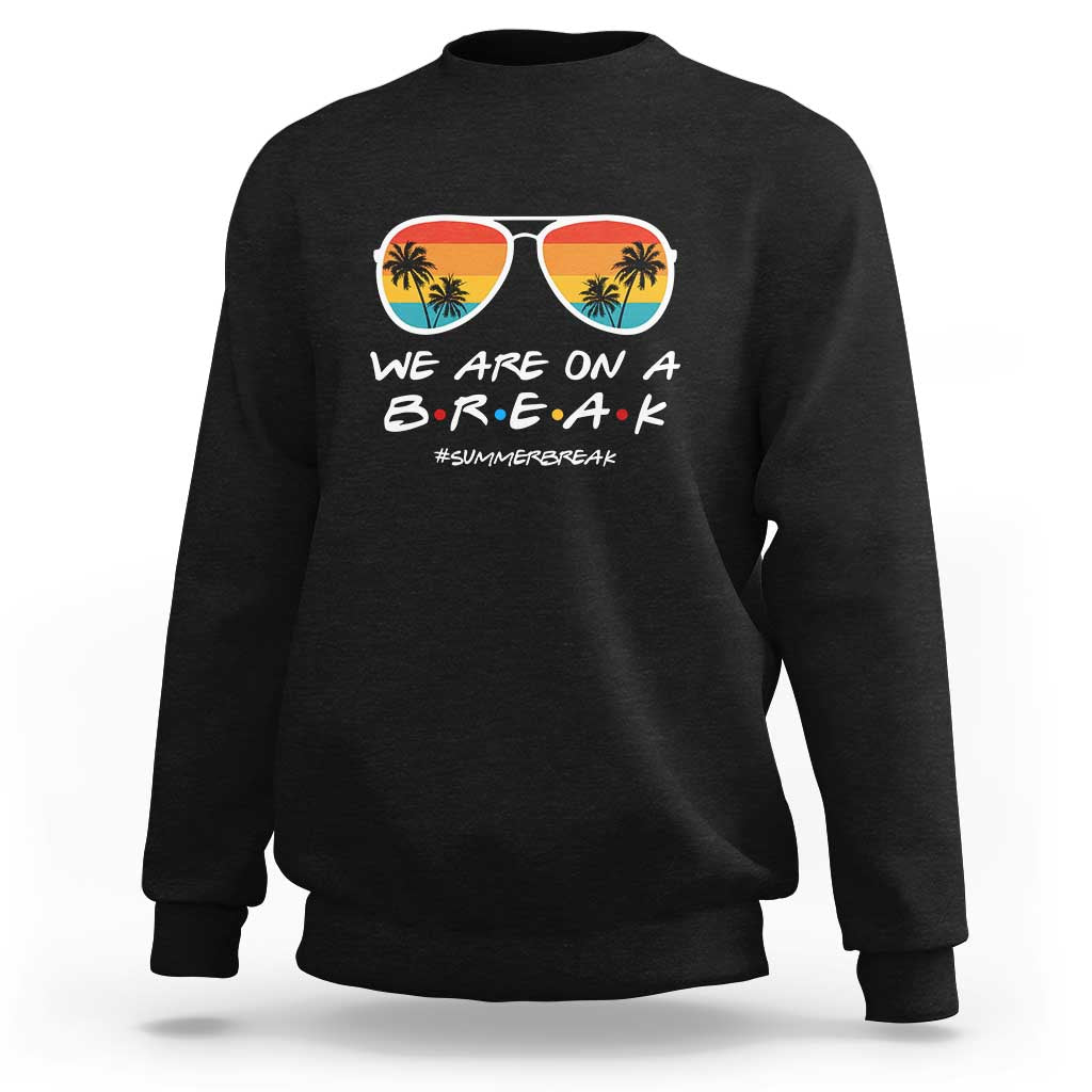 Black crewneck sweatshirt with “WE ARE ON A B.R.E.A.K” sunglasses graphic