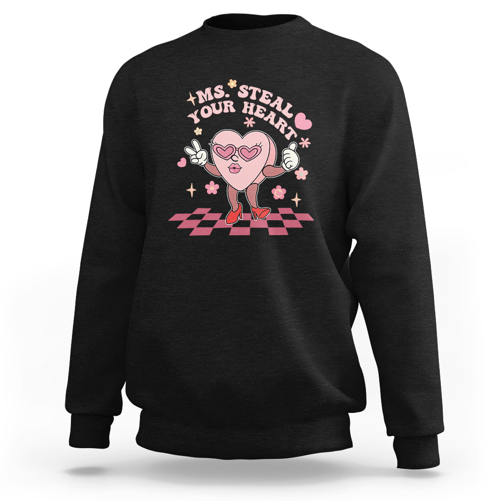 Black crewneck sweatshirt with cartoon heart graphic and 'Steal Your Heart' text
