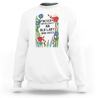 White crewneck sweatshirt with “Never Underestimate an Old Lady Who Votes” graphic
