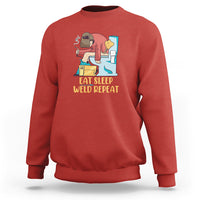 Red crewneck sweatshirt with welding graphic and “Eat Sleep Weld Repeat” text