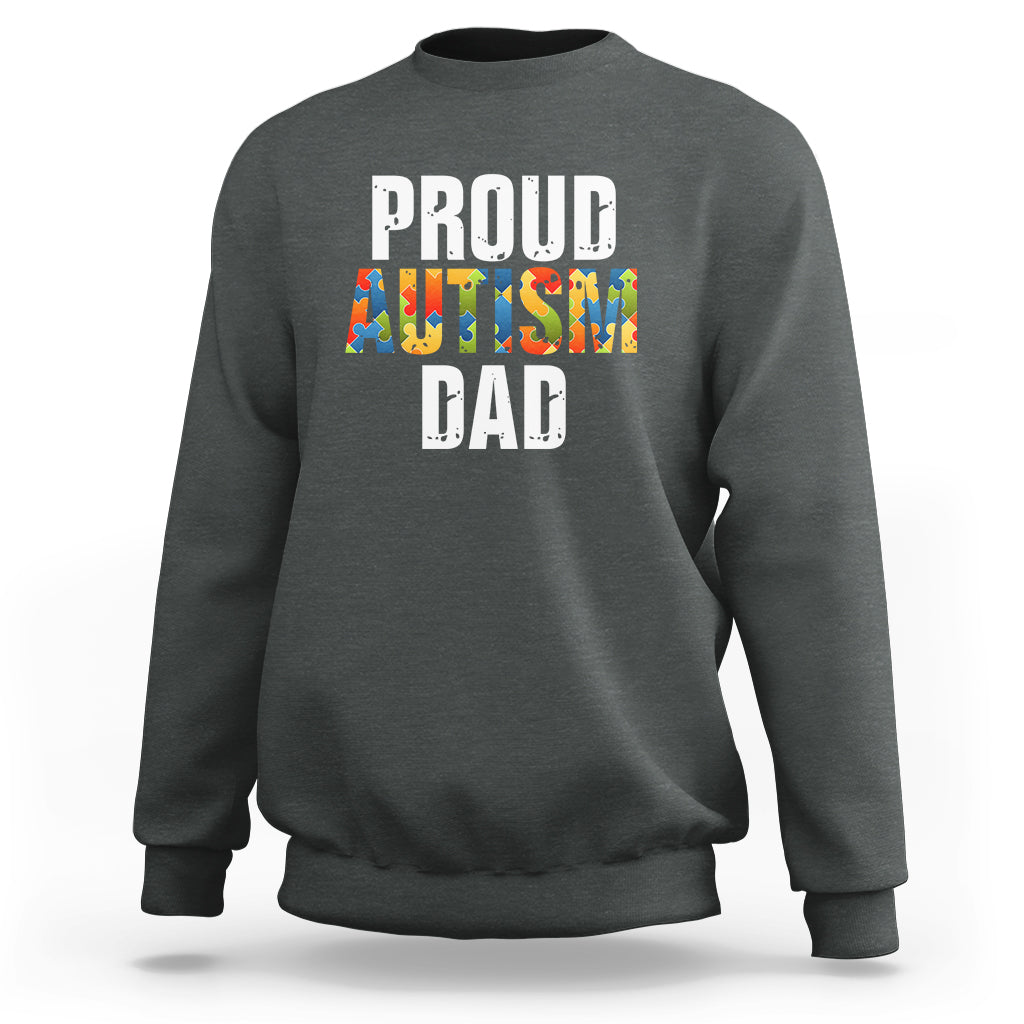 Charcoal sweatshirt with front text “PROUD AUTISM DAD” and colorful puzzle graphic.
