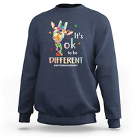 Blue crewneck sweatshirt with colorful giraffe graphic and “It’s ok to be different” message