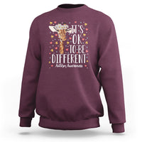 Maroon autism awareness sweatshirt with giraffe floral graphic: 'It's OK to be different'
