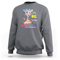 Grey autism giraffe sweatshirt with “It’s OK to be different” graphic