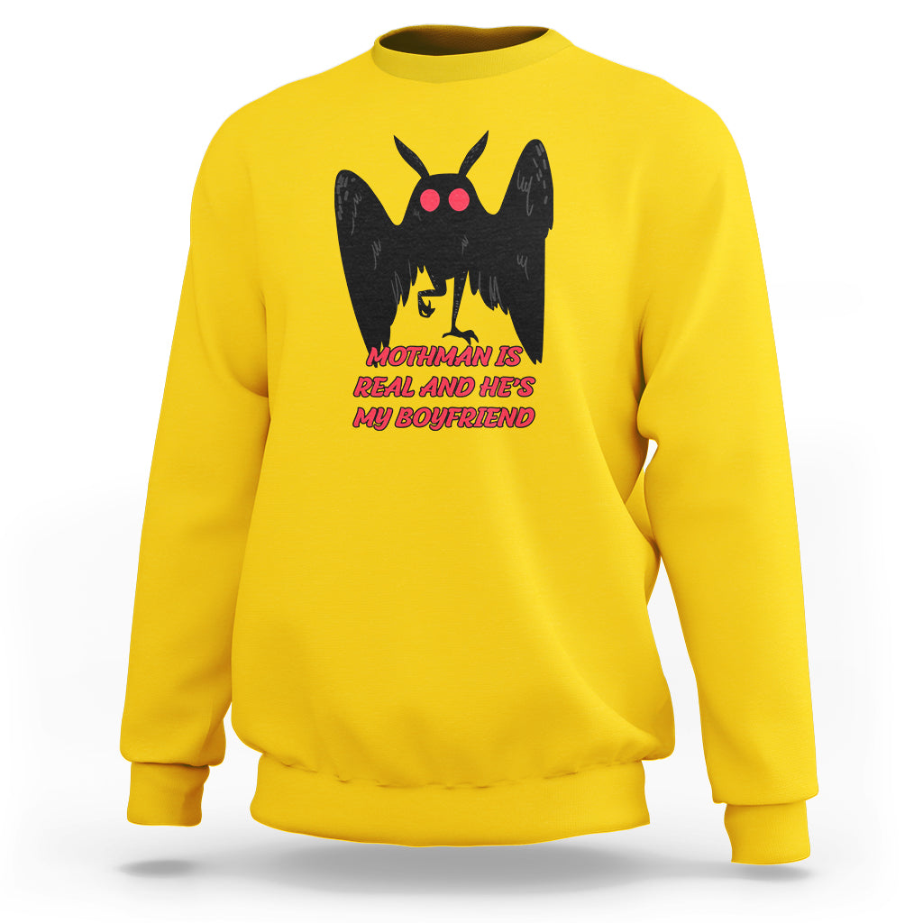 Yellow sweatshirt with black mothman graphic and red text "MOTHMAN IS REAL"