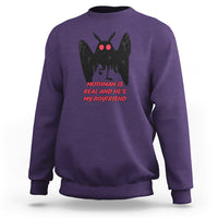 Purple sweatshirt with black mothman graphic and red text "MOTHMAN IS REAL"