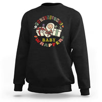 Black crewneck sweatshirt with colorful “Professional Baby Wrapper” nurse cartoon graphic