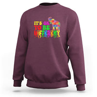 Maroon sweatshirt with colorful elephant and “It’s ok to be different” text graphic