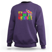 Purple sweatshirt with colorful elephant and “It’s ok to be different” text graphic
