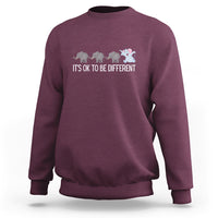 Maroon crewneck sweatshirt with elephant graphic and “It’s OK to be different” text