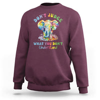 Maroon sweatshirt with colorful elephant graphic and slogan 'DON'T JUDGE' on back.