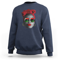 Women’s navy sweatshirt with red patterned face graphic at chest