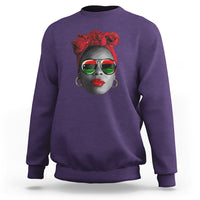 Women’s purple sweatshirt with red patterned face graphic at chest