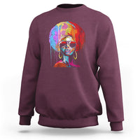Women’s maroon crewneck sweatshirt with colorful afro portrait graphic on front.