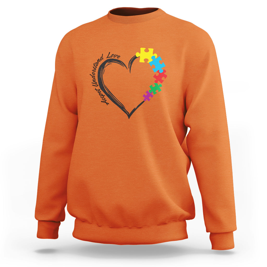 Orange autism awareness sweatshirt with heart-and-puzzle graphic on chest.
