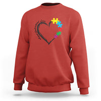 Red autism awareness sweatshirt with heart-and-puzzle graphic on chest.