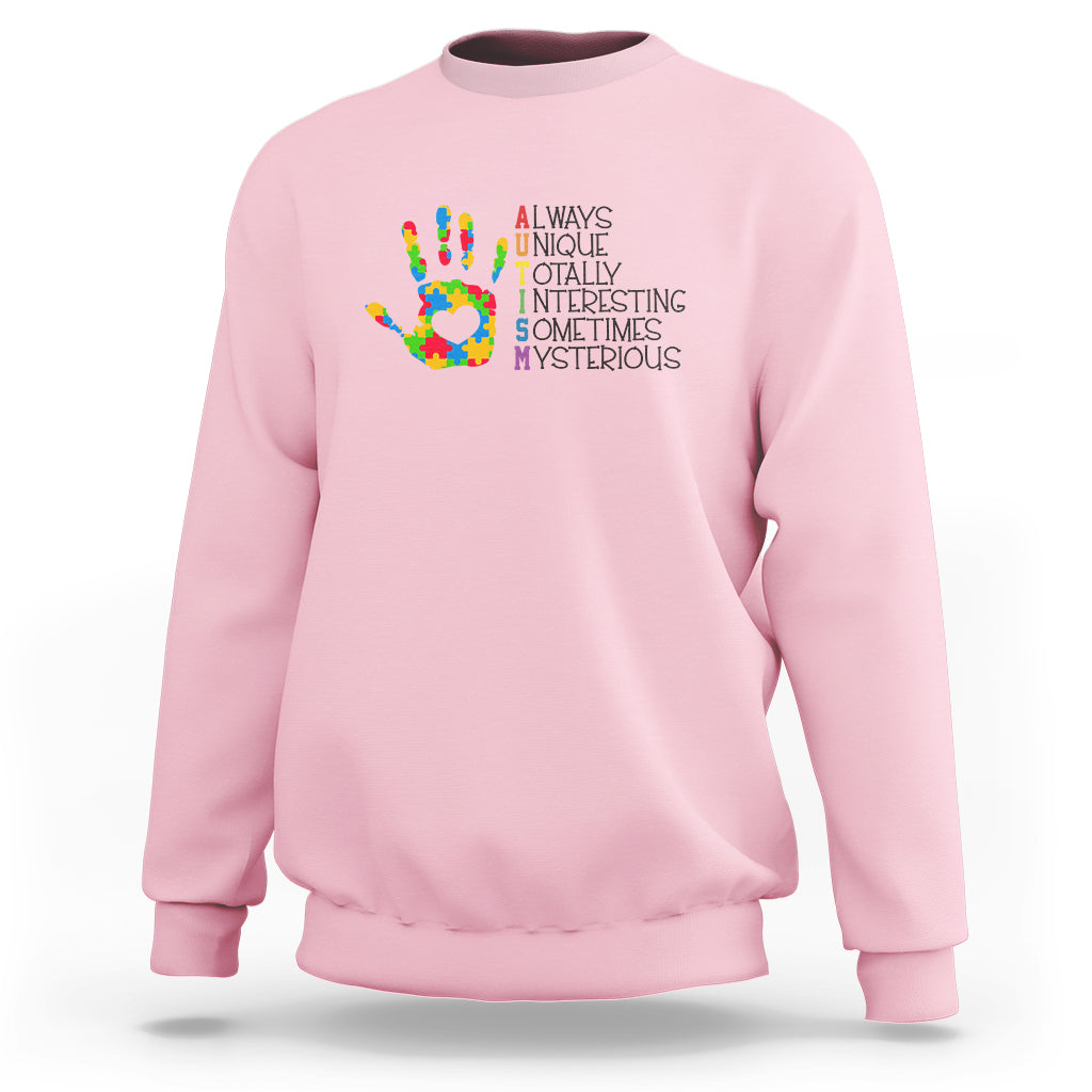 Light pink autism definition sweatshirt with multicolor puzzle hand graphic and text