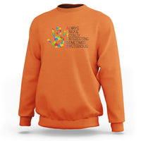 Orange autism definition sweatshirt with multicolor puzzle hand graphic and text