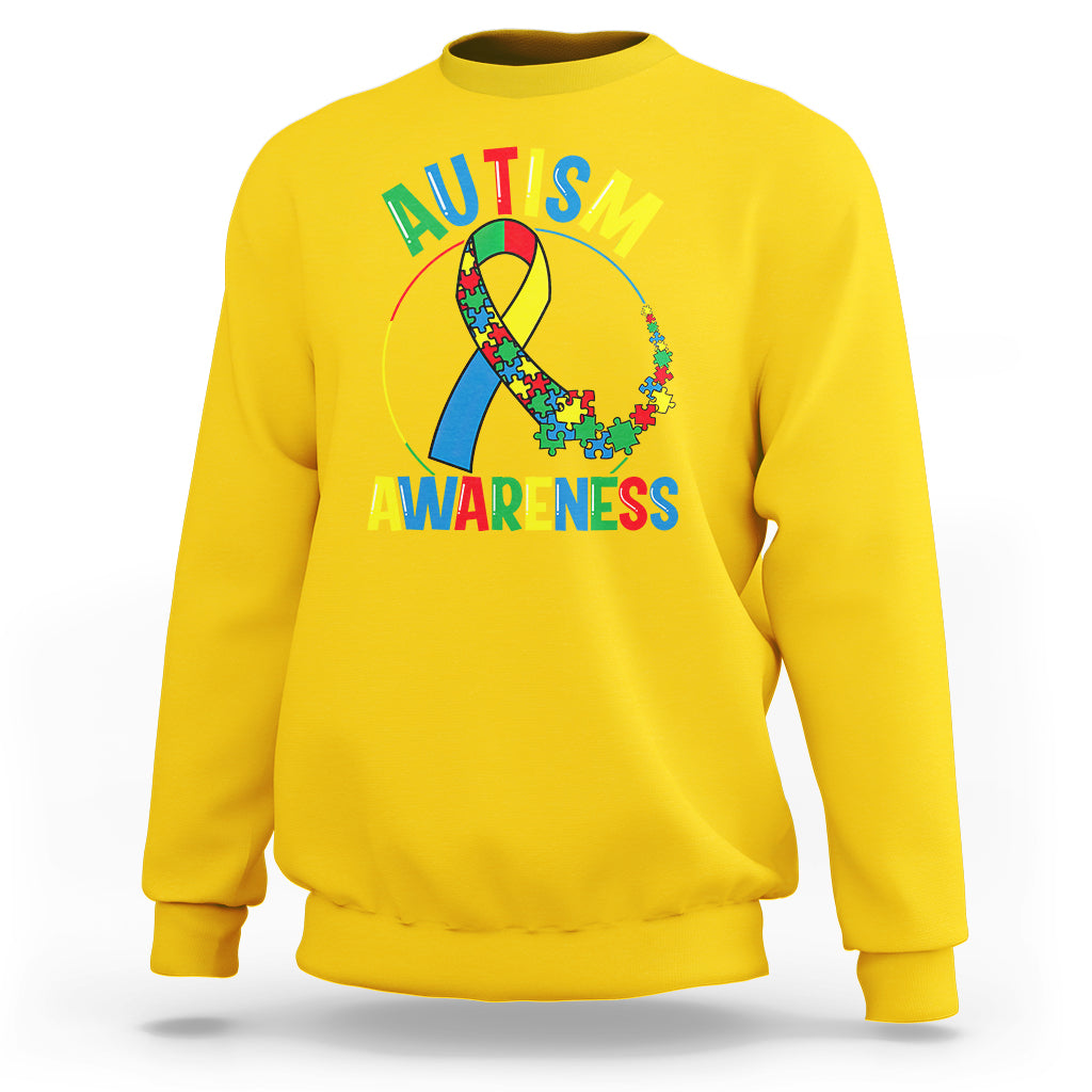 Yellow autism awareness sweatshirt with multicolor puzzle ribbon graphic and text on front