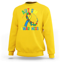 Yellow autism awareness sweatshirt with multicolor puzzle ribbon graphic and text on front