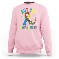 Light pink autism awareness sweatshirt with multicolor puzzle ribbon graphic on front