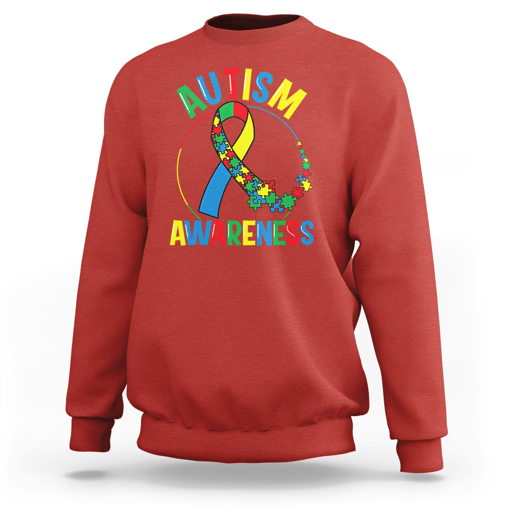Red autism awareness sweatshirt with multicolor puzzle ribbon graphic and text on front