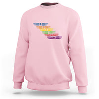 Light pink crewneck sweatshirt with multicolor autism awareness typography graphic
