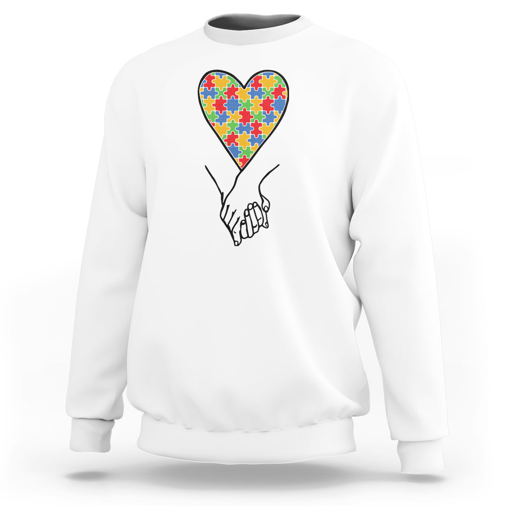 White autism awareness sweatshirt with multicolor heart puzzle graphic on front