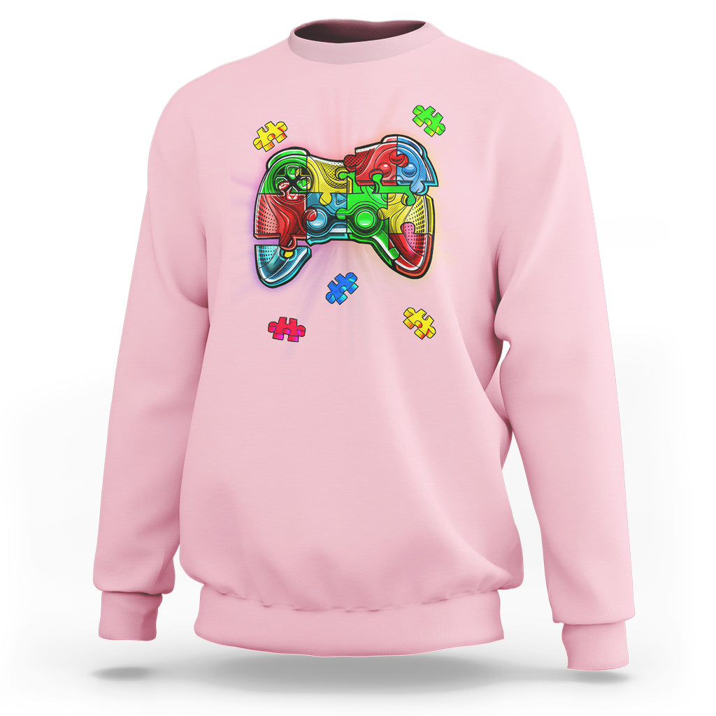 Light pink crewneck sweatshirt with colorful game controller autism puzzle graphic