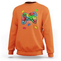 Orange crewneck sweatshirt with colorful game controller autism puzzle graphic