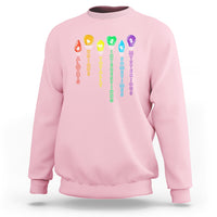 Light pink crewneck sweatshirt with colorful award and text graphic on front.
