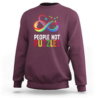 Maroon crewneck sweatshirt with “People Not Puzzles” rainbow infinity graphic
